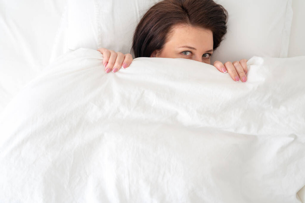 Retrato de jovem mulher bonita na cama coberta com cobertor
 - Foto, Imagem