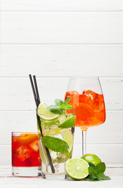 Three classic cocktail glasses on wooden table. Negroni, aperol spritz and mojito. With copy space - Photo, Image
