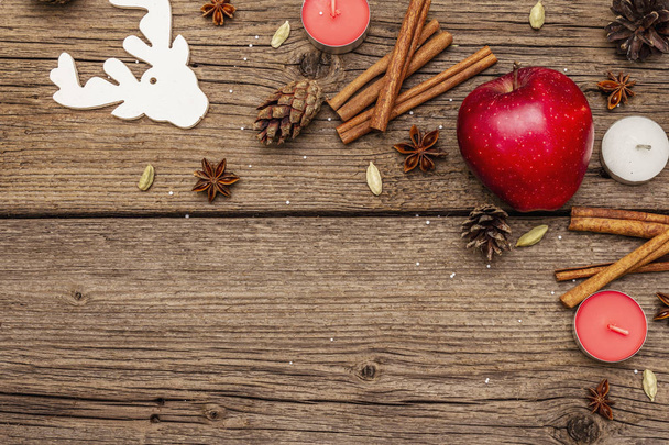 Henkinen joulutausta. Omenaa, kynttilöitä, mausteita, peuroja, käpyjä. Luonto uudenvuoden koristeet, vintage puulevyt
 - Valokuva, kuva