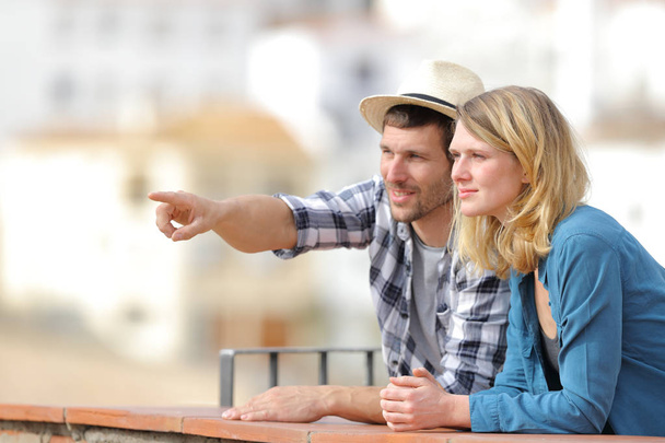 Couple of tourists sightseeing pointing at horizon - Foto, Imagem