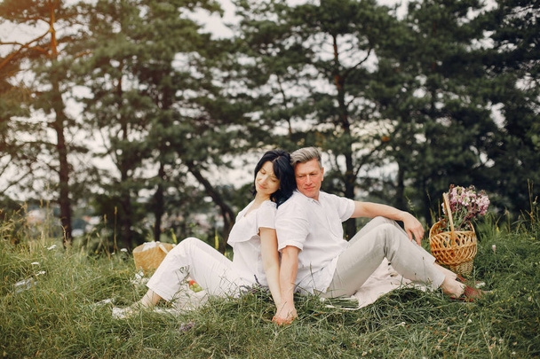 Beautiful adult couple spend time in a summer field - 写真・画像