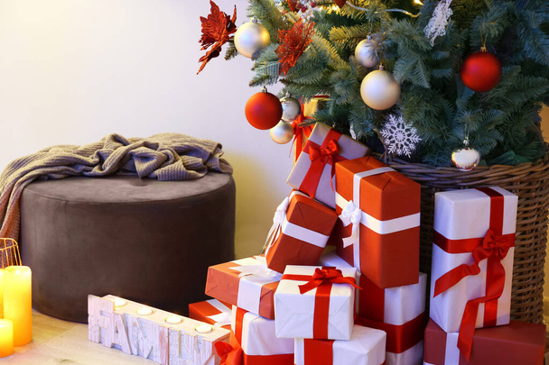 Κουτιά δώρων κάτω από διακοσμημένο χριστουγεννιάτικο δέντρο στο δωμάτιο - Φωτογραφία, εικόνα