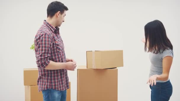Couple is moving into new flat. They have a quarrel, because dont know where to put all those big cardboard boxes. Woman is ready to throw the box at the man. - Footage, Video