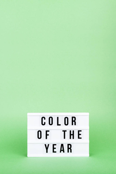 レトロなライトボックスの色の年の言葉の流行の固体緑の背景に垂直形式で - 写真・画像