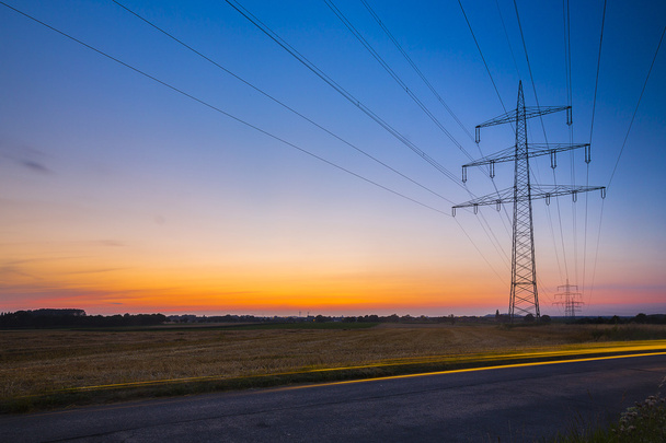 Potencia poste puesta del sol larga exposición alta tensión electricidad energía energía crepúsculo
 - Foto, Imagen