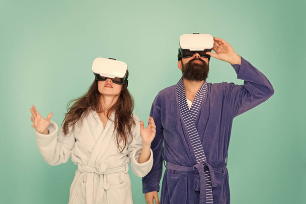 Looking upwards. Gaming and entertainment. Future closer than you think. Family explore VR at home. VR technology and future. VR communication. Exciting impressions. Couple bathrobes wear VR glasses - Photo, image