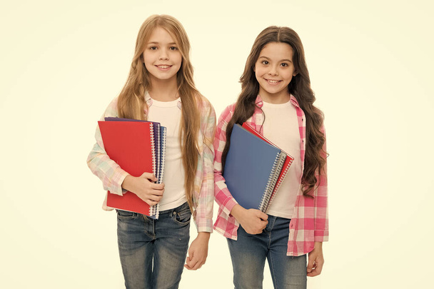 Taking extra classes. Happy to be students. Girls with school textbooks white background. School supplies concept. We love study. School stationery. Pupils carrying big textbooks to school classes - Фото, изображение