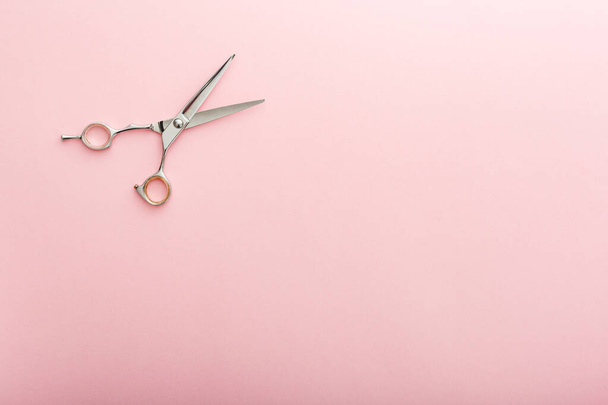 Hairdresser tools. Hairdresser scissors on pink color background with copy space for text. Hairdresser service. Beauty salon service - Foto, imagen