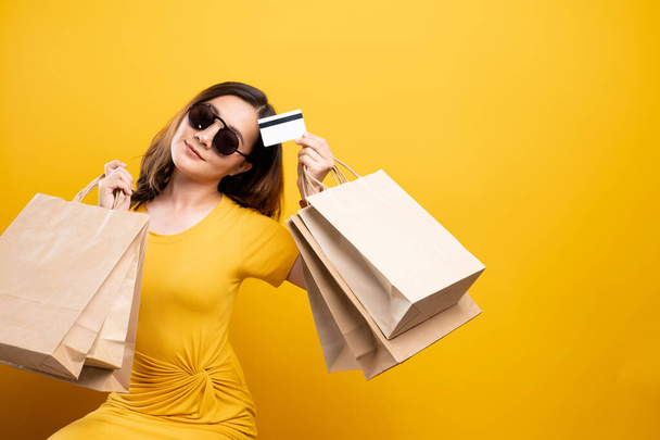 Szczęśliwa kobieta trzyma torby na zakupy i karty kredytowe odizolowane ponad  - Zdjęcie, obraz
