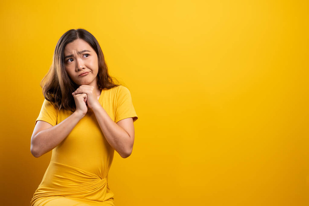Frau fühlt sich vor gelbem Hintergrund verwirrt - Foto, Bild