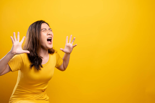 Angry woman screaming isolated over yellow background - Фото, изображение