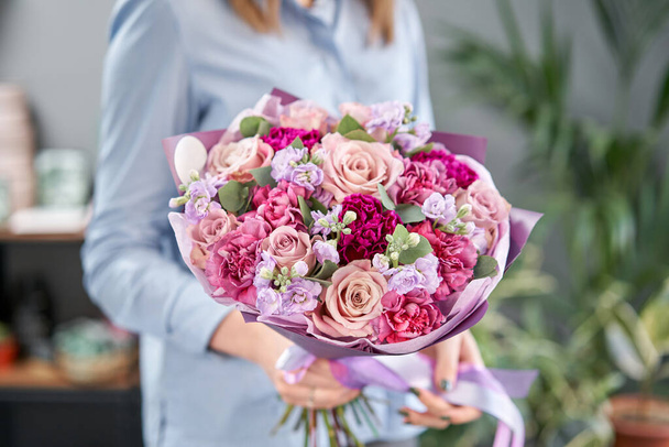 European floral shop. Beautiful bouquet of mixed flowers in womans hands. the work of the florist at a flower shop. Delivery fresh cut flower. - Φωτογραφία, εικόνα