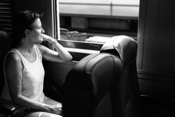 Portrait of mature beautiful Scandinavian tourist woman at railway station of Bangkok, Thailand in black and white - Foto, Imagem