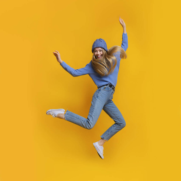 Breezy girl in blue jumping in the air - Photo, Image