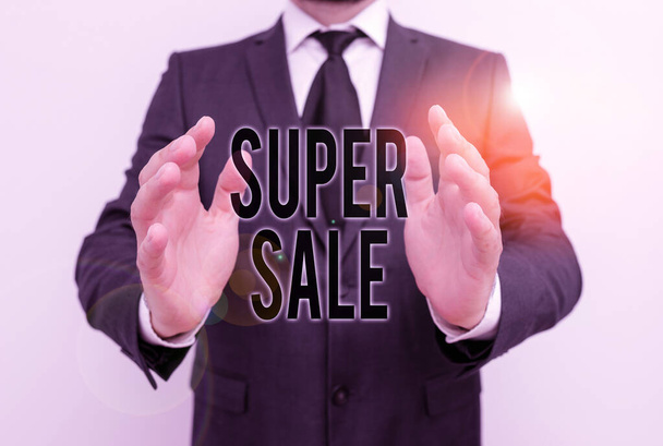 Writing note showing Super Sale. Business photo showcasing offering exceptional discounts on selected products and services Male human with beard wear formal working suit clothes hand. - Photo, Image