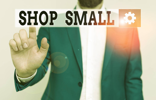 Text s rukopisem Shop Small. Koncept znamená celonárodní hnutí, které oslavuje malé podniky každý den Podnikatel v modrém apartmá a bílé košili ukazuje prstem v prázdném prostoru. - Fotografie, Obrázek