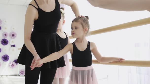 Eine Frau und ein Mädchen in einer Ballettschule. Die erwachsene Ballerina übt mit den kleinen Mädchen und trainiert das klassische russische Ballett - Filmmaterial, Video