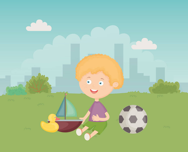 cute blond boy sitting with toys in the meadow - Vector, Image