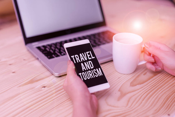 Writing note showing Travel And Tourism. Business photo showcasing Temporary Movement of People to Destinations or Locations woman with laptop smartphone and office supplies technology. - 写真・画像