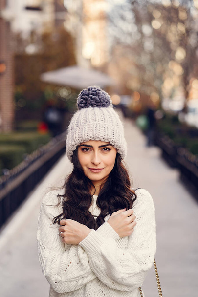 Cute brunette in a white sweater in a city - Foto, Imagen