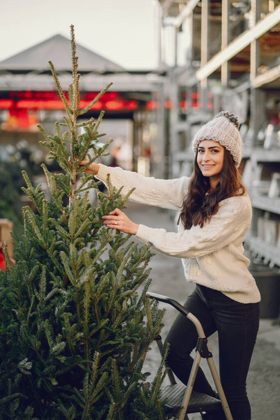 Cute brunette in a white sweater with Christmas tree - Valokuva, kuva