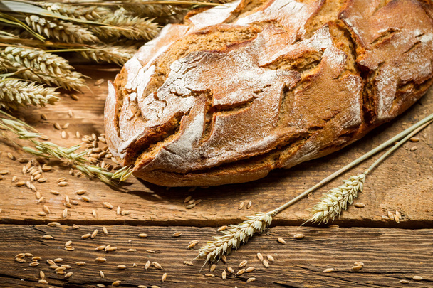 Loaf of bread in a rural bakery with wheat - Foto, immagini