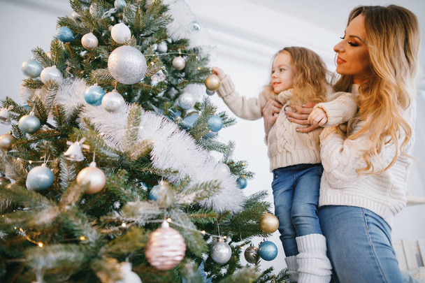 mother and daughter decorating the tree - Fotoğraf, Görsel
