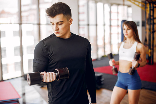 A beautiful sports couple is engaged in a gym - Foto, immagini