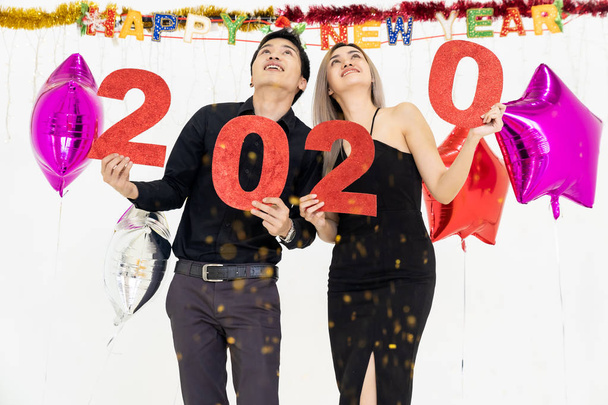 Young couple at a party holding red number of year 2020. Happy New Year celebration. - Foto, Imagem