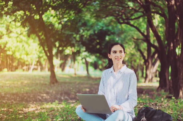 Beautiful young woman using laptop computer at public park in the morning,Happy and smiling,Relaxing time,Positive thinking - Fotografie, Obrázek