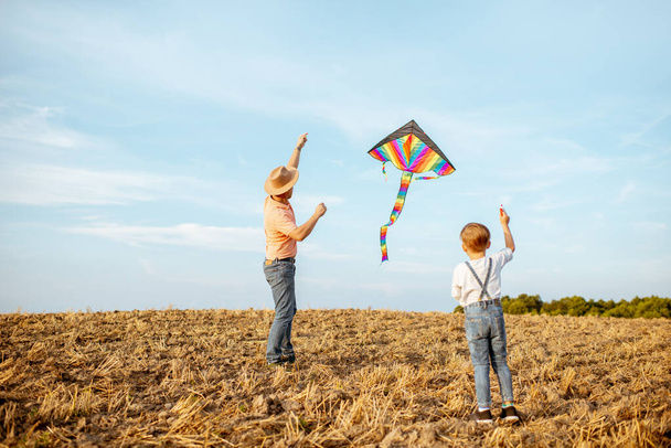 Fother and son flying kite on the field - Foto, Imagem
