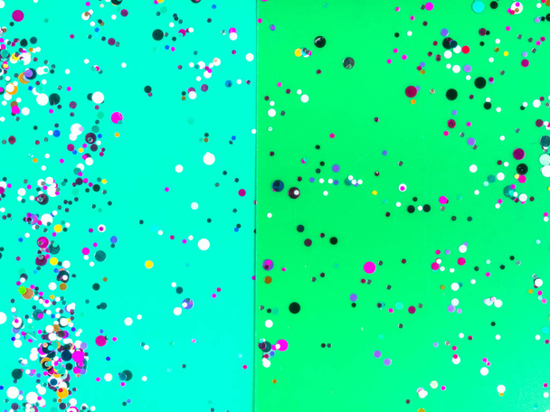 Papierblätter in gemischten grünen Farben mit holographischer Folie Konfetti. Trendy Mint und grüne abstrakte Duo-Ton-Hintergrundgestaltung. Platz für Text. Haupttrend und einfaches Urlaubskonzept. Ansicht von oben - Foto, Bild