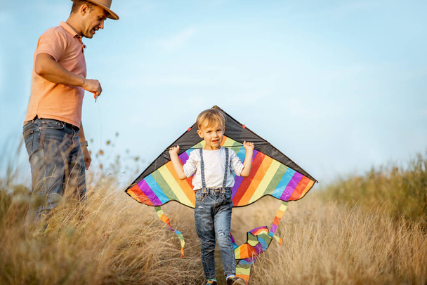Father and son with air kite in the field - Φωτογραφία, εικόνα