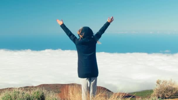 Svoboda cestovatel žena stojí se zdviženými pažemi na vrcholu hory na Tenerife a vychutnat krásné nad mraky, cestování, svoboda, Kanárské ostrovy - Záběry, video