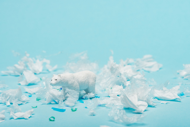 Valkoinen lelu jääkarhu muovia roskat sinisellä pohjalla, eläinten hyvinvoinnin käsite
 - Valokuva, kuva