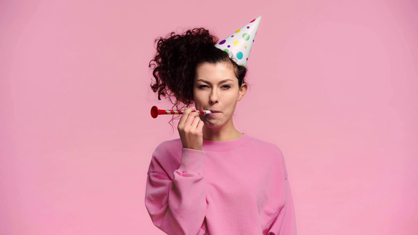 happy woman blowing in party blower isolated on pink  - Footage, Video