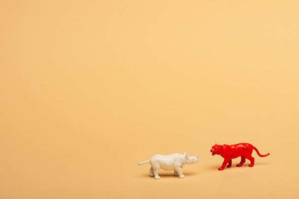 Toy rhinoceros and tiger on yellow background, animal welfare concept - Photo, Image