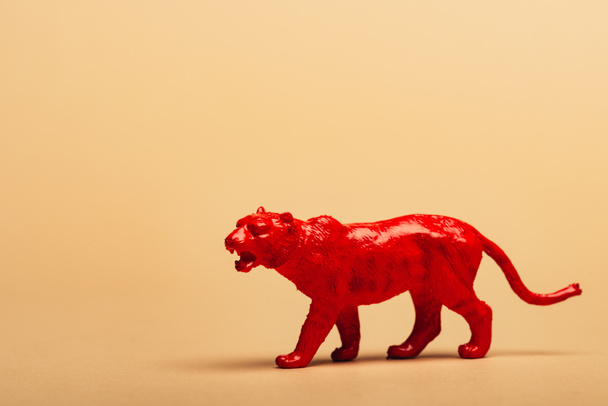 Red toy tiger on yellow background, animal welfare concept - Foto, Bild