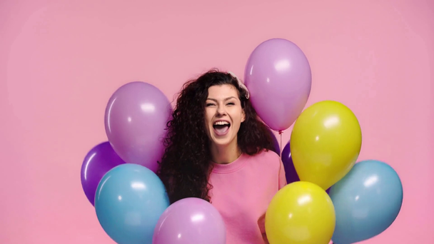 szczęśliwy dziewczyna gospodarstwa balony izolowane na różowy  - Materiał filmowy, wideo