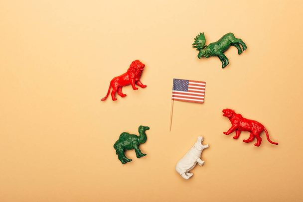 Visão superior de animais de brinquedo com bandeira americana no fundo amarelo, conceito de bem-estar animal
 - Foto, Imagem