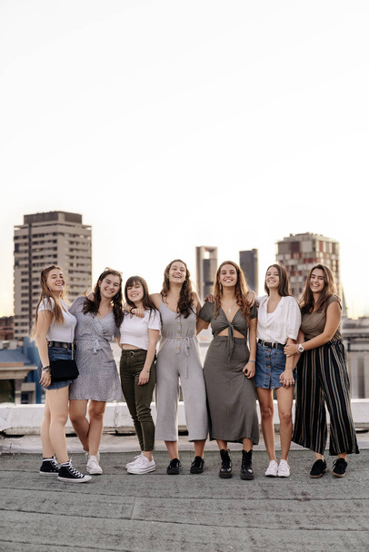 Big group of pretty girls smiling and having fun in a rooftop - Photo, Image