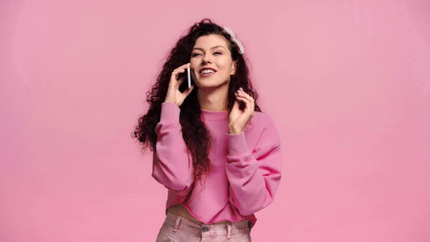 mujer feliz hablando en el teléfono inteligente aislado en rosa
  - Metraje, vídeo