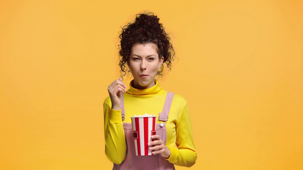 happy girl eating popcorn isolated on orange  - Séquence, vidéo