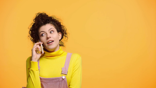 happy girl talking on smartphone isolated on orange  - Metraje, vídeo