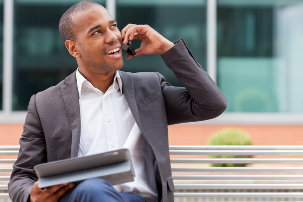 Successful african businessman phoning while smiling - Foto, Bild