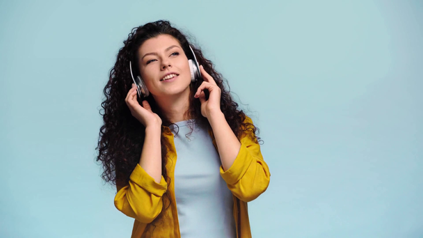 alegre chica escuchando música aislado en azul
  - Metraje, vídeo