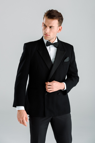 hombre rico guapo en traje de pie aislado en gris
  - Foto, Imagen