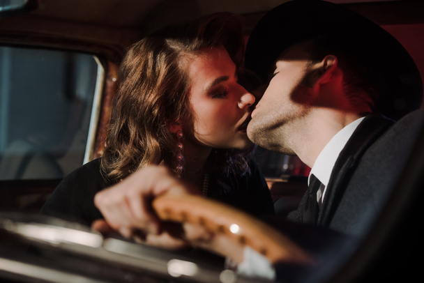 foco seletivo de casal beijando no carro retro
  - Foto, Imagem