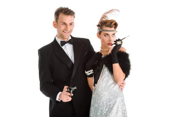 happy man with gun standing near woman with cigarette holder isolated on white  - Photo, Image