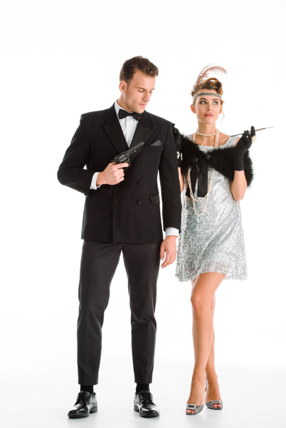handsome man holding gun near attractive woman with cigarette isolated on white  - Photo, Image